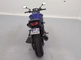 a blue motorcycle parked in a room with a white wall