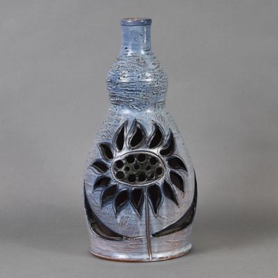 un vase contenant une fleur, posé sur une table