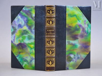 un vieux livre dont la couverture est dorée et verte sur un fond blanc