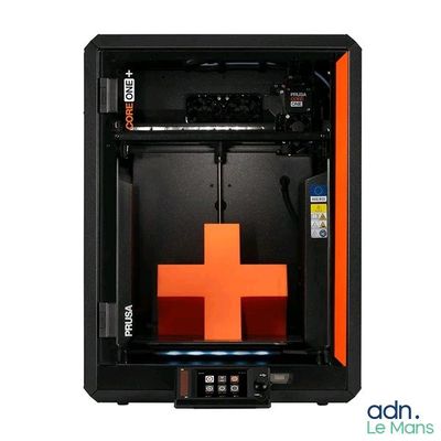 une image représentant une imprimante 3D noire et orange sur laquelle figure une croix rouge