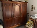 une chambre à coucher comprenant un lit, une commode, une chaise et une armoire