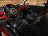 the interior of a small red car with a steering wheel and dashboard