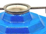 a close up of a blue vase with a metal handle