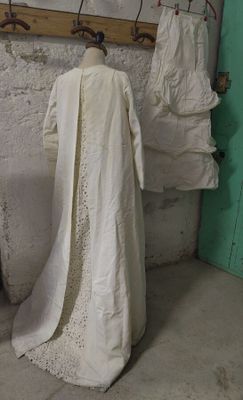 une robe blanche suspendue à un portant dans une pièce