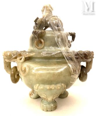 un grand vase vert surmonté d'un oiseau