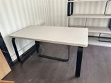 a white desk with black legs in a room
