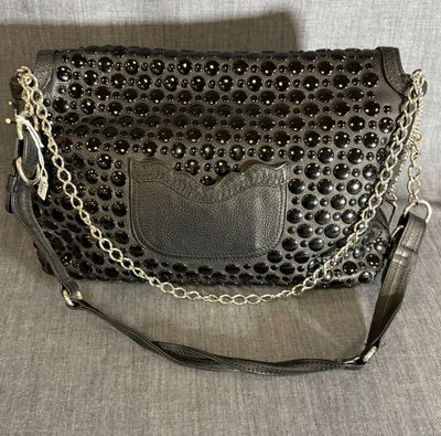 un sac à main noir avec une chaîne autour de la bandoulière et une chaîne autour de la bandoulière