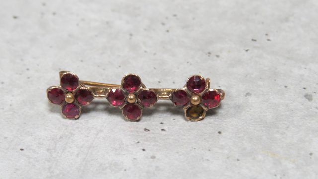 Broche en or 750‰, à motif de fleurs, sertie de pierre rouge. En ...