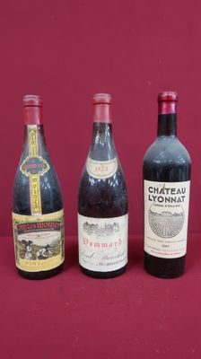 four bottles of wine are lined up on a red surface