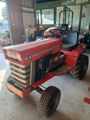 a red tractor that is parked in a garage