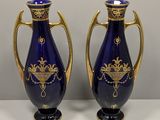 une paire de vases bleus et dorés posés sur une table blanche