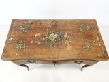 a small wooden table with a floral design on it
