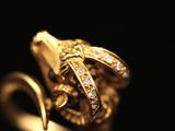 a close up of a gold ring with diamonds on a black background