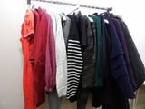 a lot of clothes hanging on a rack in a room