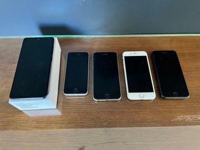 three iphones are sitting on a table next to a box