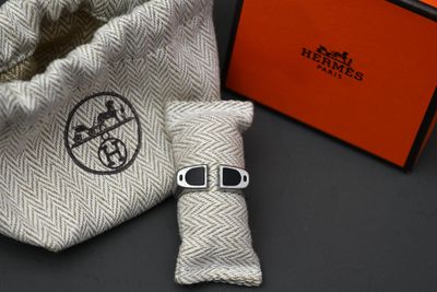 une boîte orange et un sac blanc sur lequel est représentée une montre