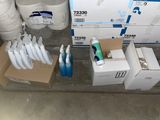 several boxes of toothbrushes and toothpaste are on the floor