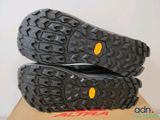 the soles of a pair of black hiking shoes on top of a cardboard box