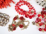 many different types of beads and necklaces on the table