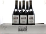 three bottles of wine sit on top of a box in front of a window