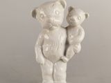 une statue blanche représentant un ours tenant un ourson dans ses bras