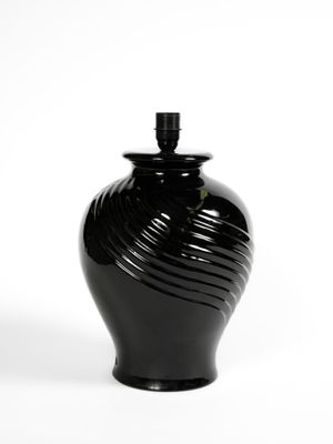un vase noir posé sur une surface blanche