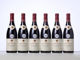 six bouteilles de vin sont alignées sur une table