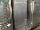 two stainless steel ovens sitting in a warehouse