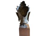 statue of a bird perched on a wooden block on a white background
