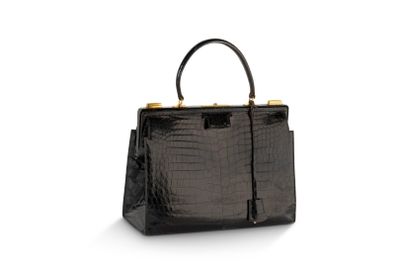 un sac à main en cuir de crocodile noir sur fond blanc
