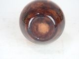 a brown glass ball sitting on a white surface