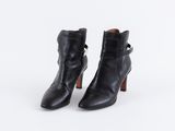 une paire de bottines en cuir noir à talon en bois