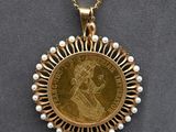 a close up of a gold coin with pearls on a necklace