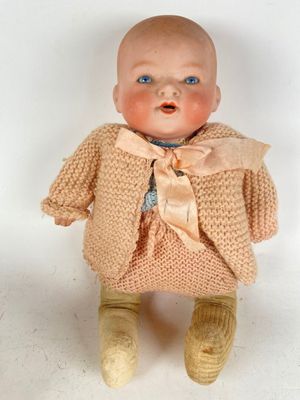 a small doll that is wearing a sweater and pants