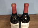 two bottles of wine sitting on a wooden table