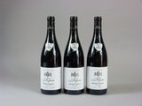 trois bouteilles de vin sont alignées sur une table
