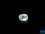 a close up of a green diamond on a black surface