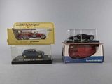 two toy cars are in a display case on a table