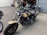 des motos garées devant un immeuble, avec un garage en arrière-plan