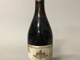 une vieille bouteille de vin posée sur une table blanche