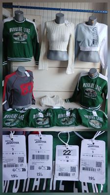 un présentoir de t-shirts et de casquettes exposés dans un magasin
