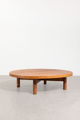 une table basse ronde avec des pieds en bois et un plateau en bois