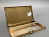 a small gold box with a handle on a table