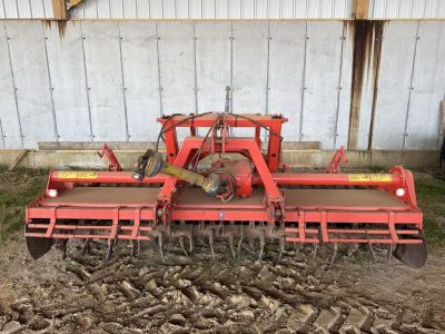 une image représentant un tracteur rouge en train de labourer un champ