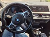 someone is sitting in the driver ' s seat of a bmw car