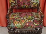 an old chair with a colorful upholstered seat