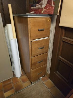 a picture of a woman sitting on top of a dresser next to a refrigerator