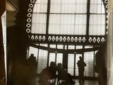 une photo en noir et blanc montrant des personnes dans un grand bâtiment