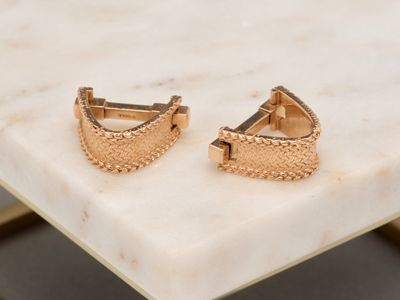 the gold plated cuff earrings are set on a marble table