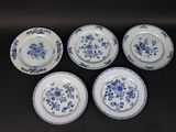 six blue and white plates with floral designs on them on a black surface
